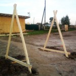 В верхних точках боковые опоры в форме равнобедренных треугольников соединяются перекладиной, к которой подвешивается сидение